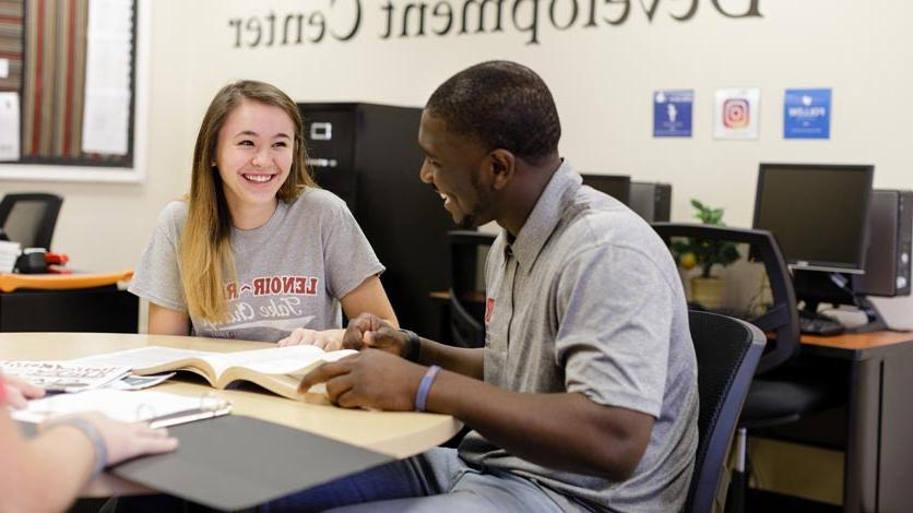 Two talking at table in career development center